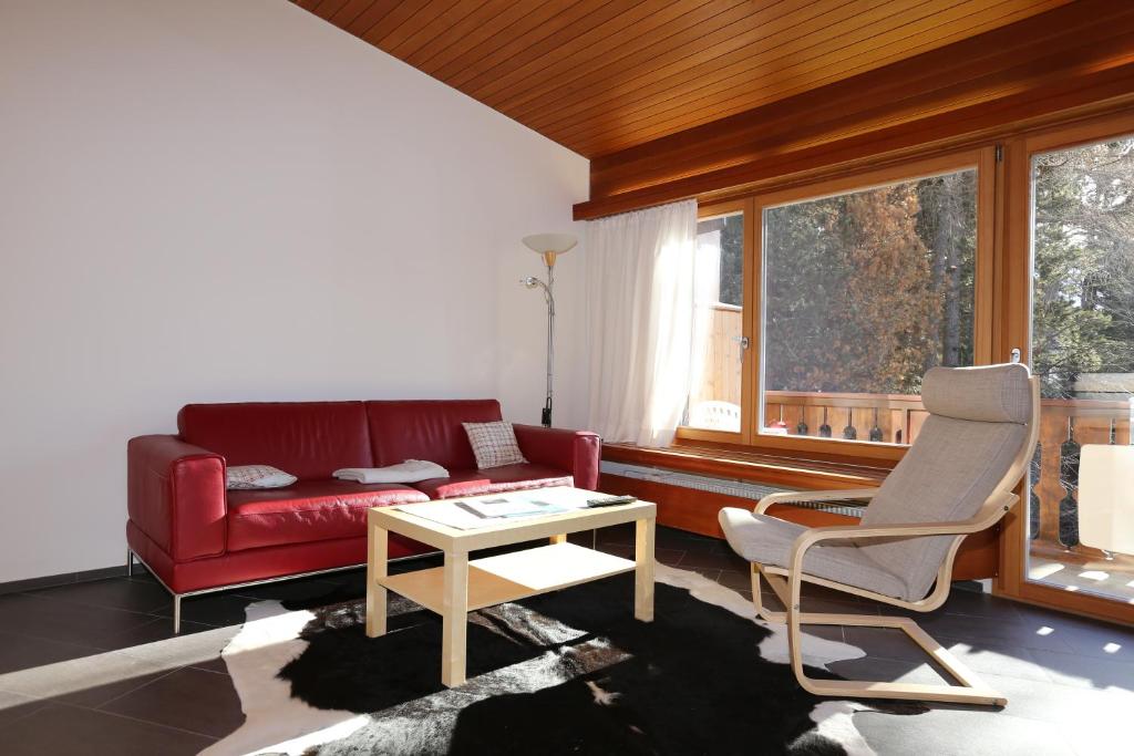 ポントレジーナにあるChesa Blaisのリビングルーム(赤いソファ、テーブル付)
