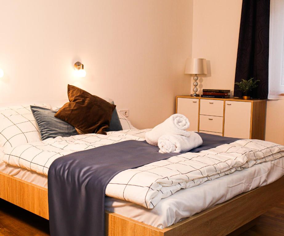 1 dormitorio con 1 cama con 2 toallas en Villa Blue Apartman, en Szekszárd