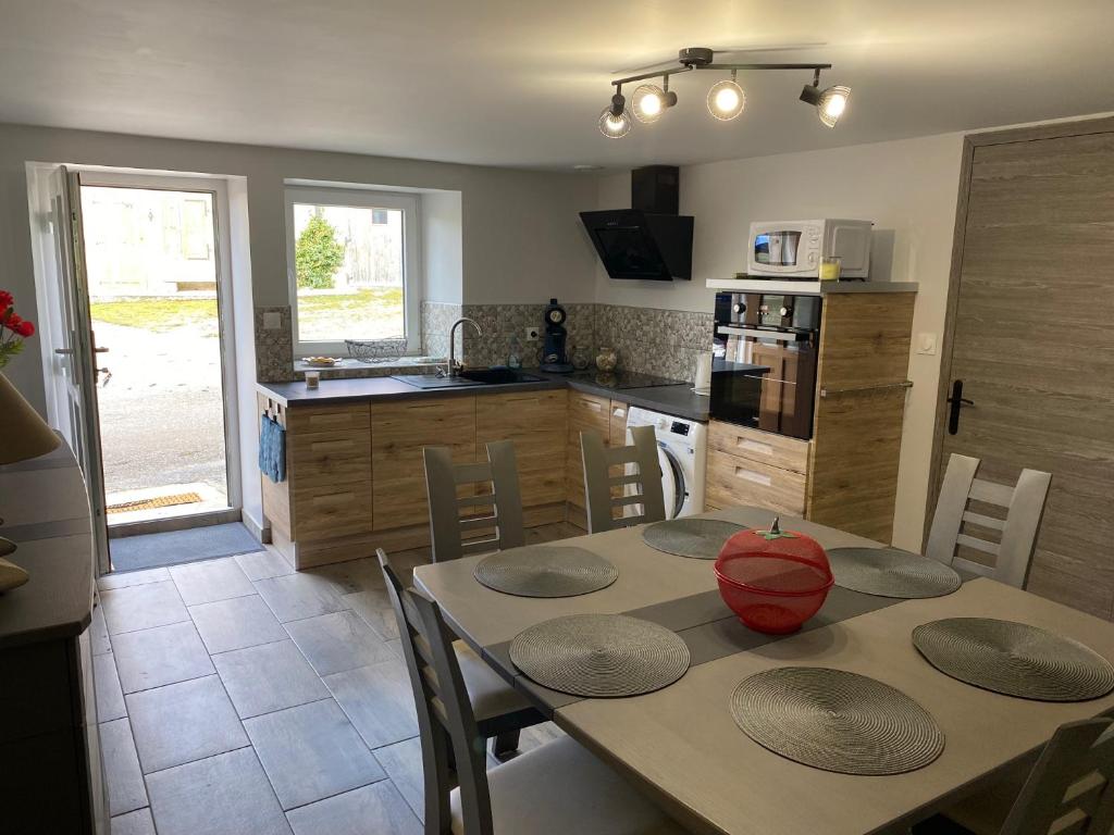 a kitchen with a table and chairs and a kitchen with a counter at LE GITE DU LYNX N°2 in Cernon