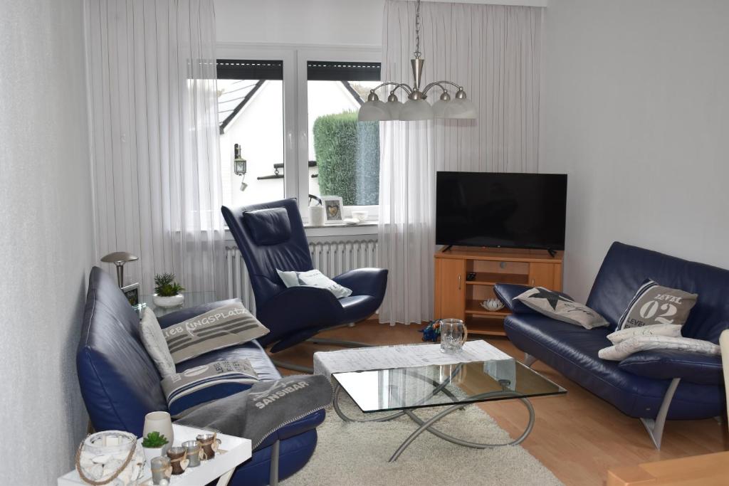 a living room with blue couches and a tv at FeWo am Naturschutzgebiet in Hiddenhausen