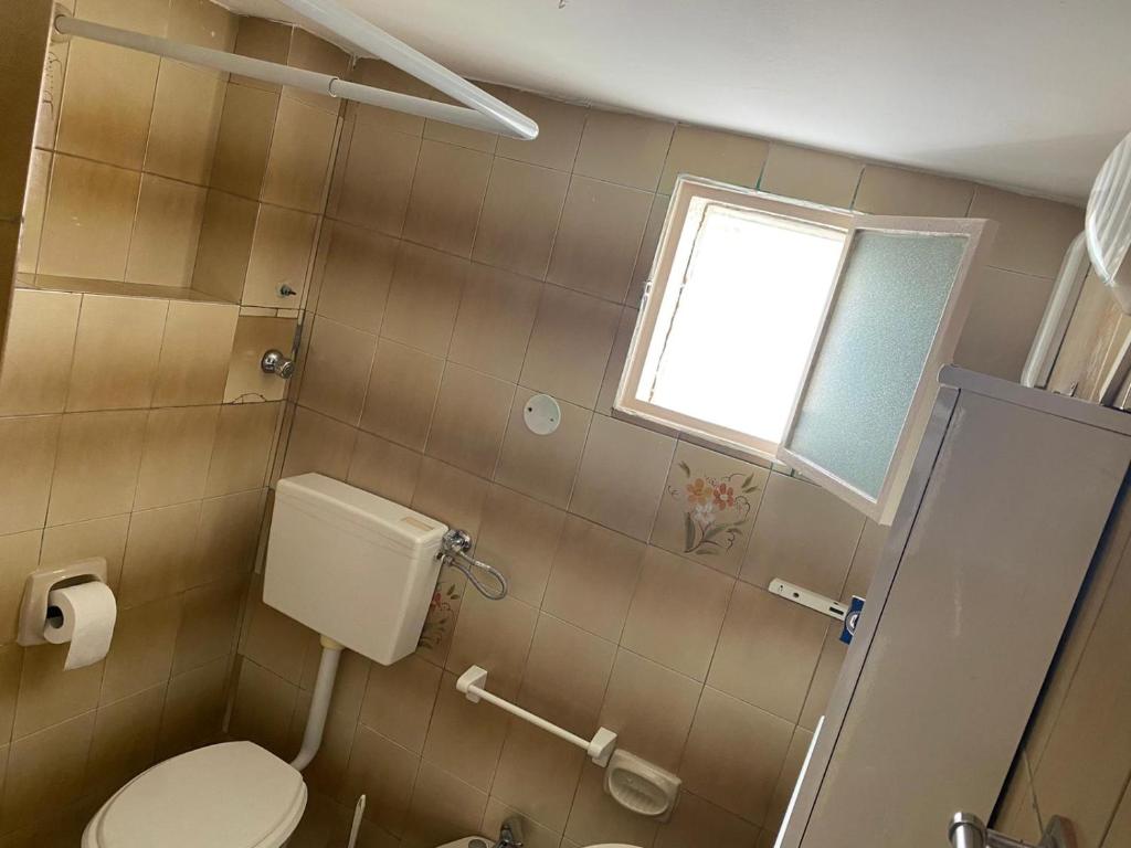 a bathroom with a toilet and a window at La Casa di Giorgio in Marina di Camerota