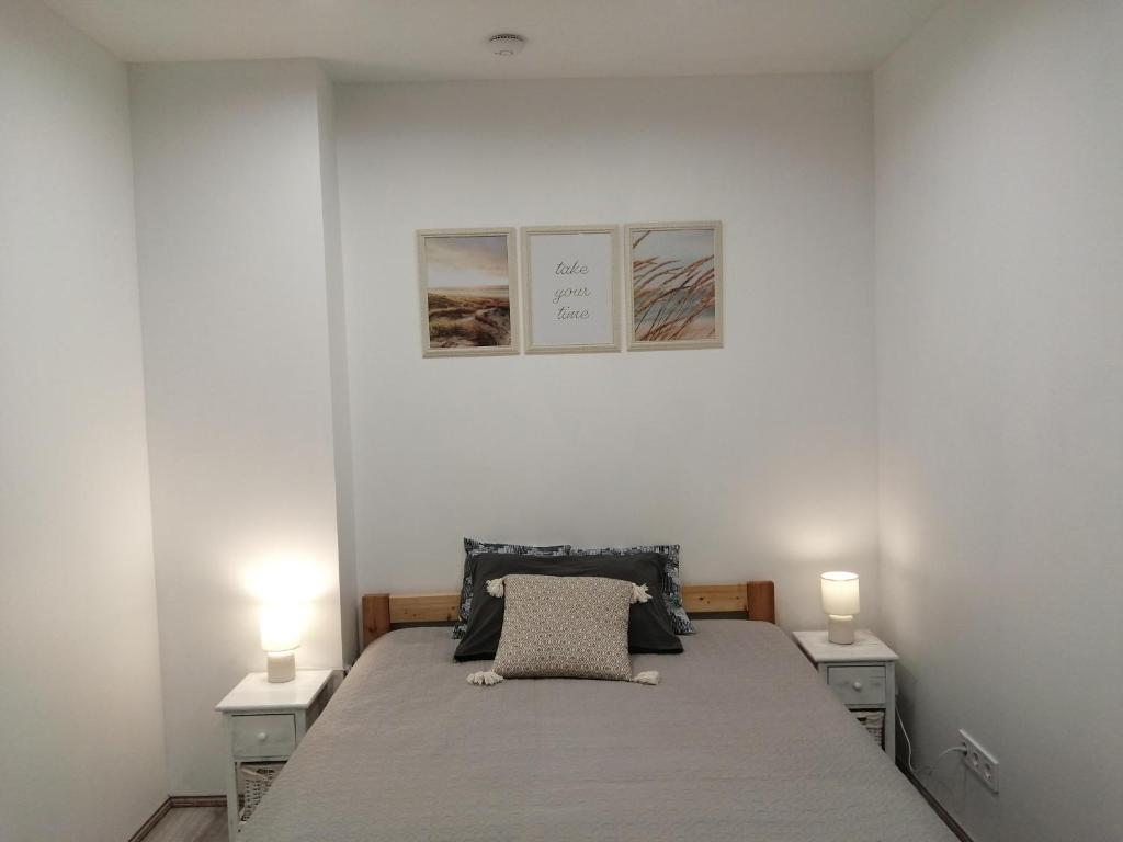 um quarto com uma cama com duas mesas de cabeceira e dois candeeiros em PortStreet apartamenti em Liepāja