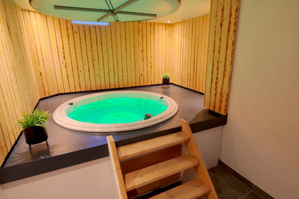 une baignoire jacuzzi dans une chambre avec une échelle dans l'établissement Jacuzzi & Sauna Villa 2, à Tzummarum