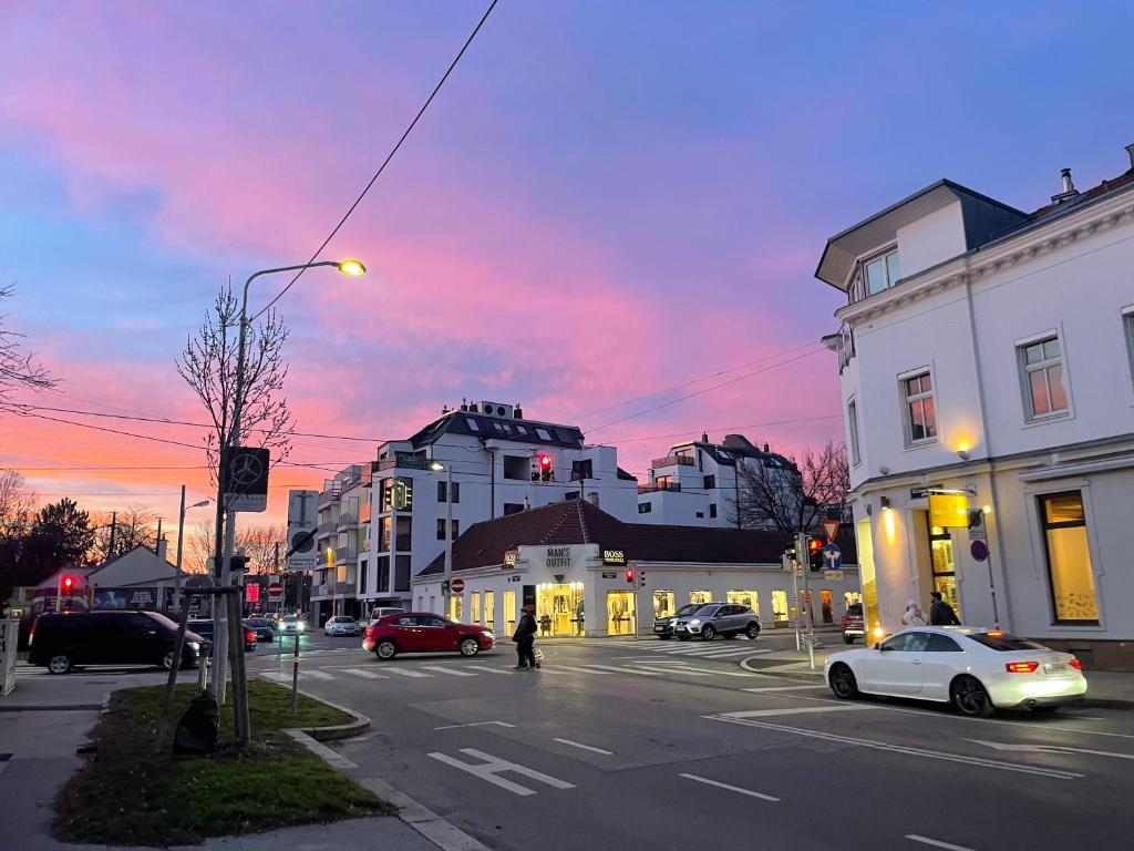 una calle de la ciudad al atardecer con coches en la calle en A place to call home en Viena