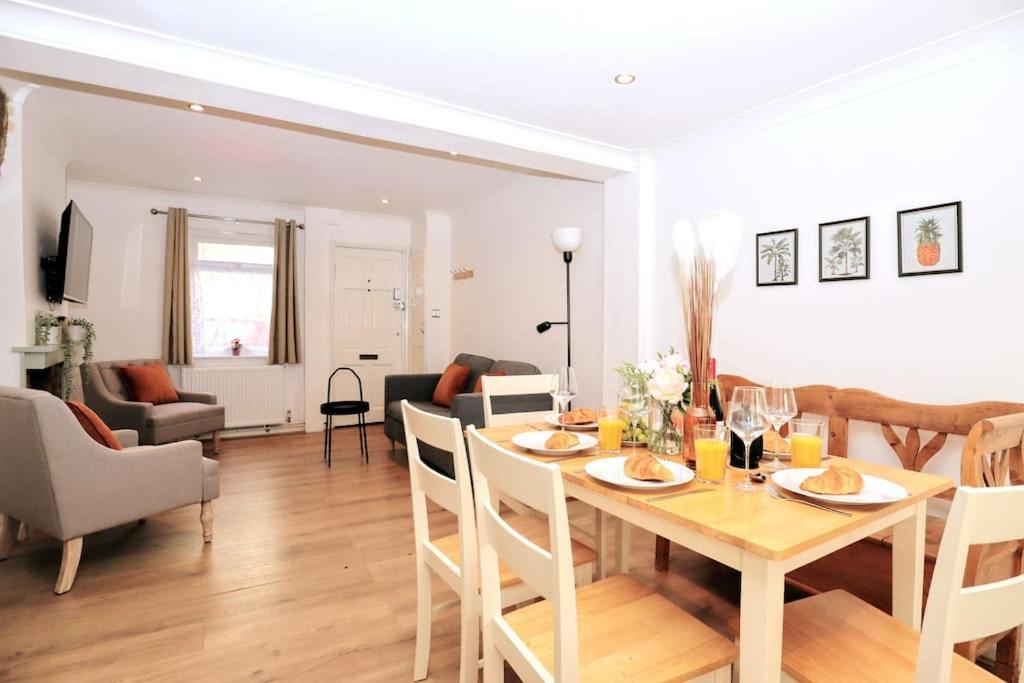 a dining room and living room with a table and chairs at Cute Central Georgian Cottage in Hastings