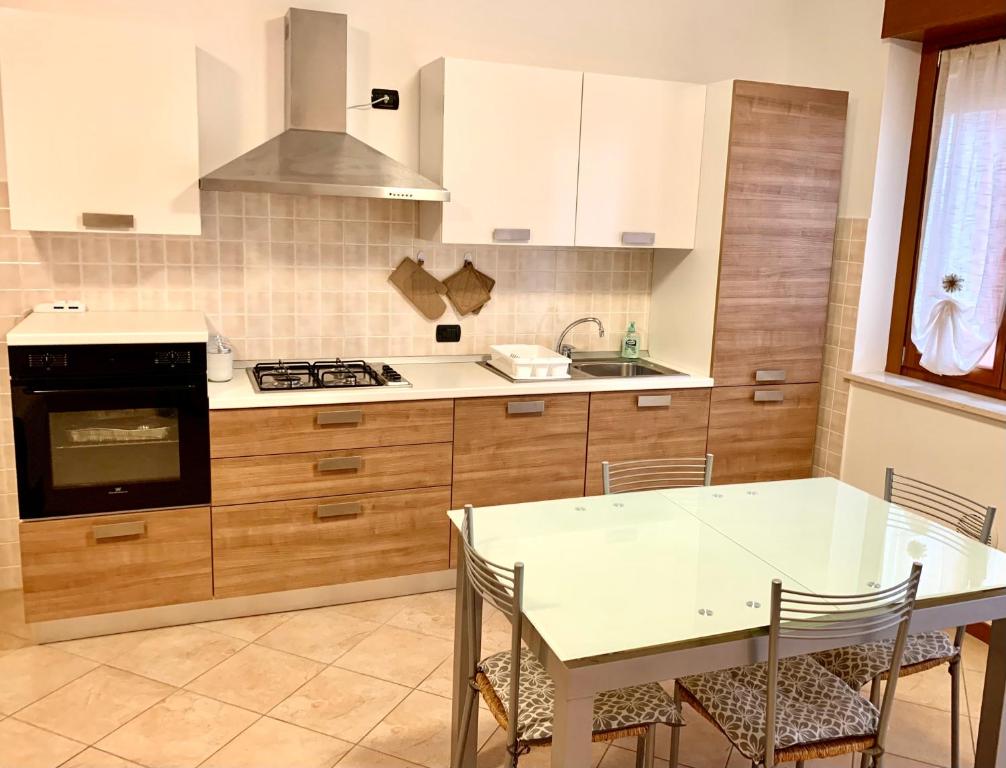 uma cozinha com uma mesa e um fogão forno superior em Top Apartment 2 em Castel d'Azzano