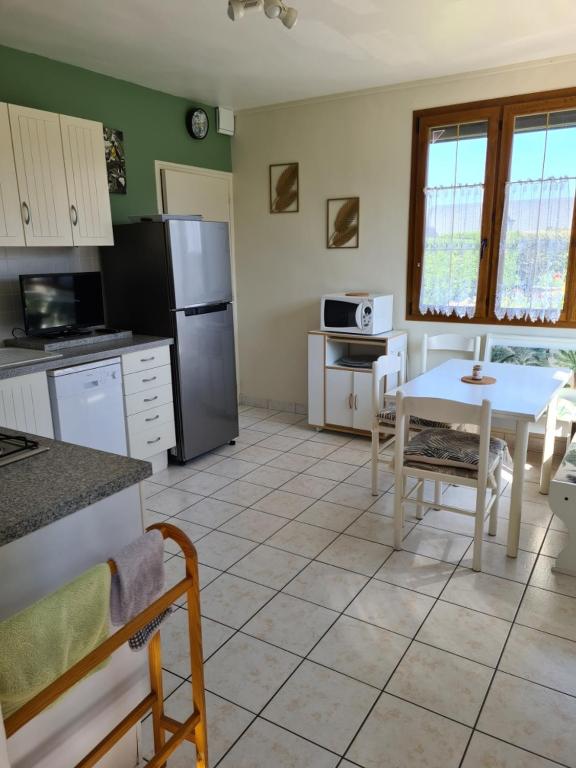 a kitchen with a table and a refrigerator and a table at Les embruns in Petit-Berneval