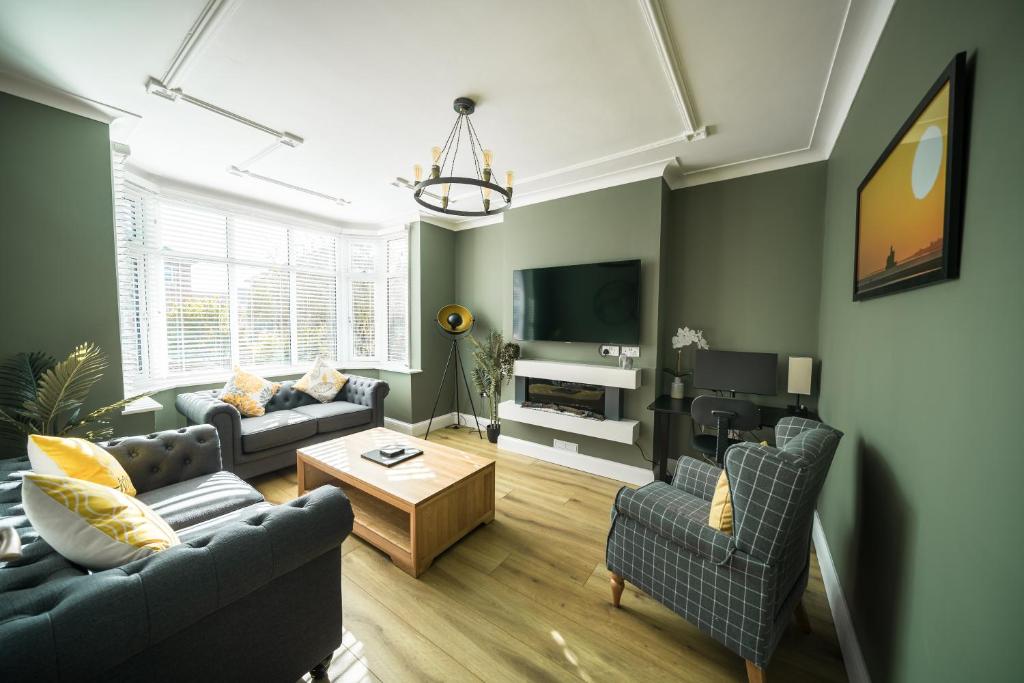 a living room with two couches and a tv at Highgate Beach House in Cleethorpes