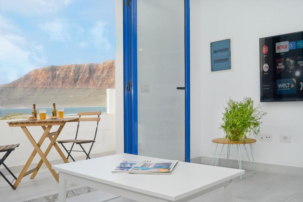 a table and chairs in a room with a view of the ocean at Luxury Buenavista Famara in Famara