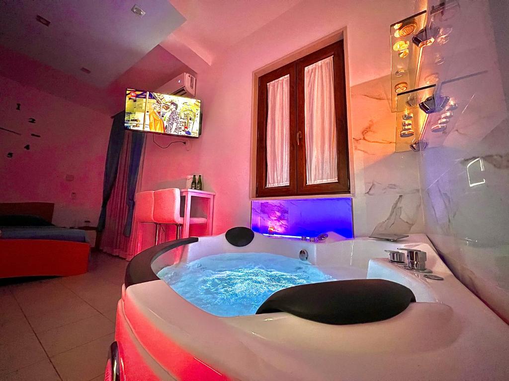 a bathroom with a tub in a pink room at Villa Latino in Vieste