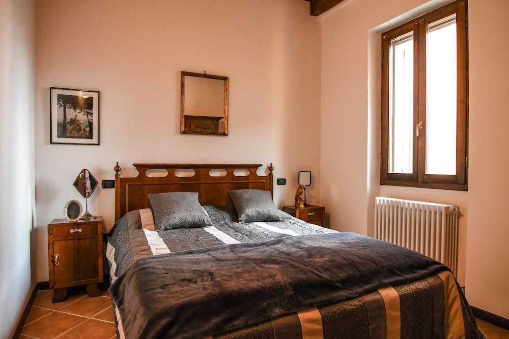 a bedroom with a large bed and a window at La Casa di Clelia in Brisighella