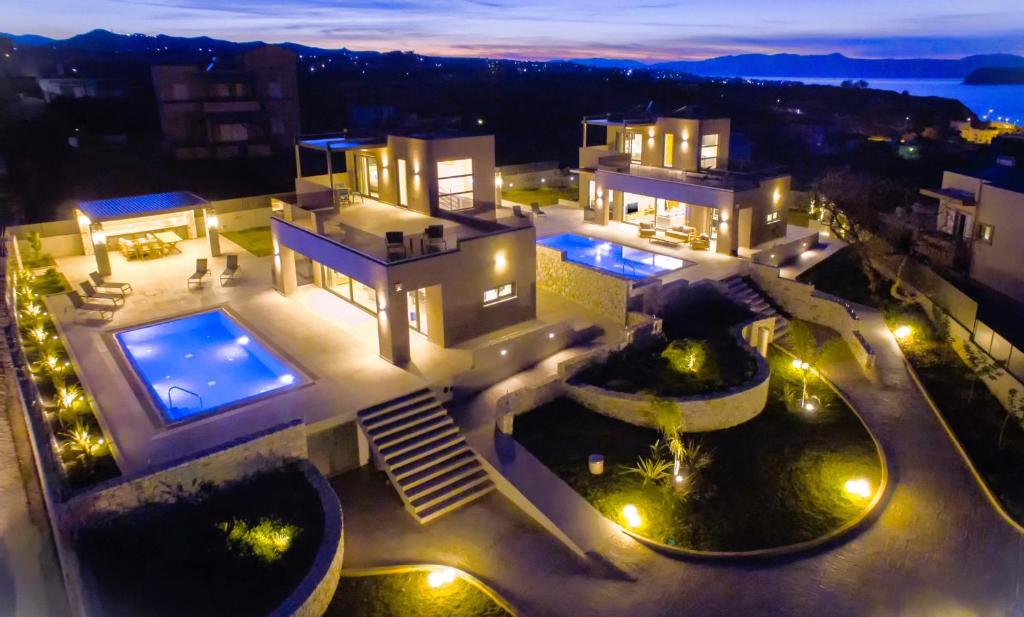 an aerial view of a house at night with lights at Imperium Luxury Villas-Sauna, Jacuzzi, Heated Pool & Gym-Chania in Kato Galatas