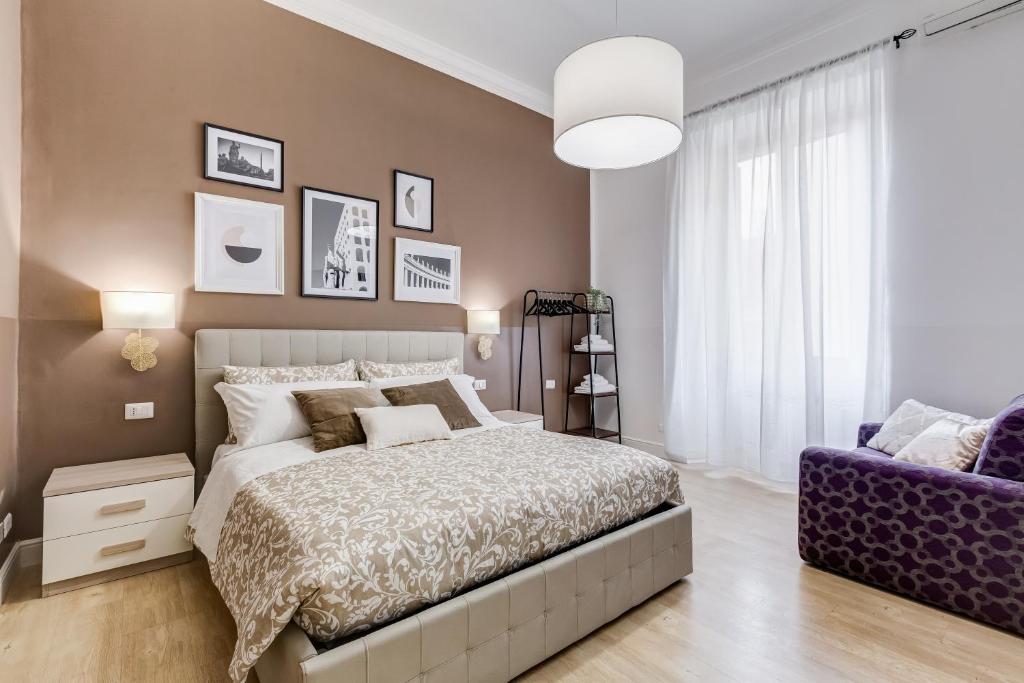 ein Schlafzimmer mit einem großen Bett und einem lila Stuhl in der Unterkunft BDC - The Choice, your 2-Bdr apt in Vatican district in Rom