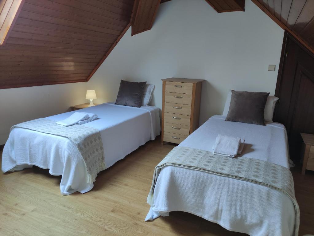 a bedroom with two beds and a dresser at casa cardeal saraiva in Ponte de Lima