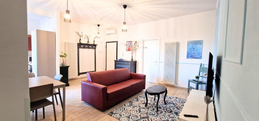 ein Wohnzimmer mit einem roten Sofa und einem Tisch in der Unterkunft Central City Rooms m09 Apartment in Bologna