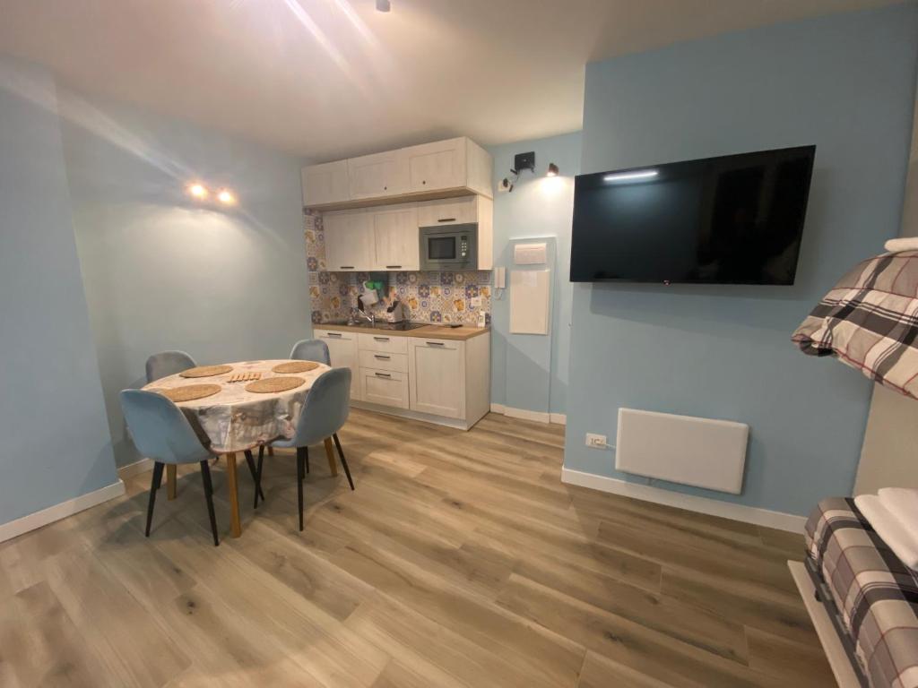 a dining room with a table and a kitchen at Sendy Home Roccaraso 2 in Roccaraso