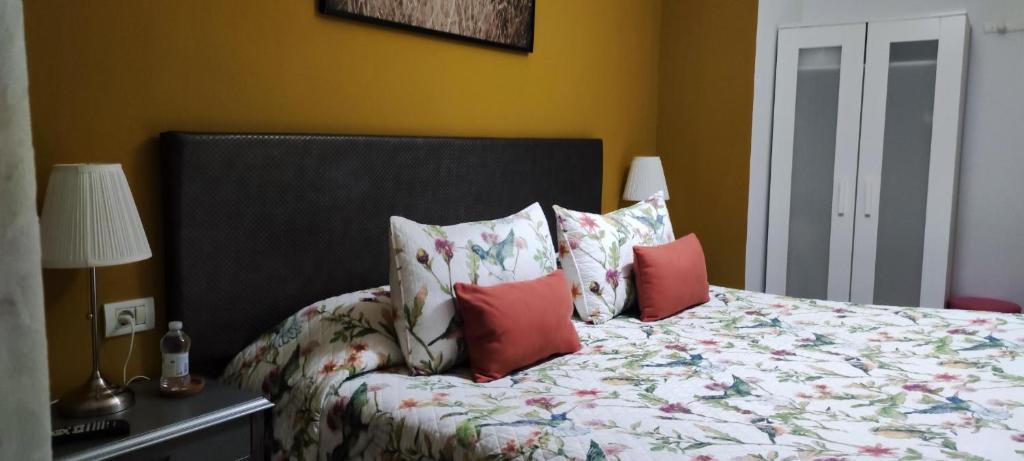 1 dormitorio con 1 cama con almohadas rojas en Finca Rural La Casa Verde Shalom Tenerife, en La Laguna