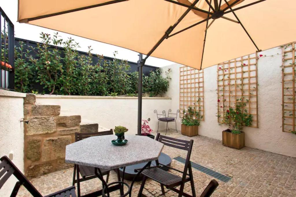 a table and chairs with an umbrella on a patio at Urban Cabin in Vila Nova de Gaia