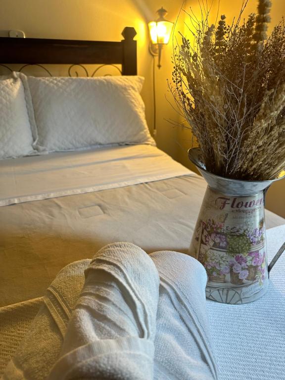 una camera con letto e vaso con fiori di Deck Hospedaria a Cunha