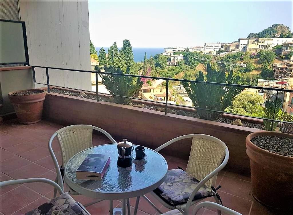 d'une table et de chaises sur un balcon avec vue. dans l'établissement Dolce Casa Taormina, à Taormine