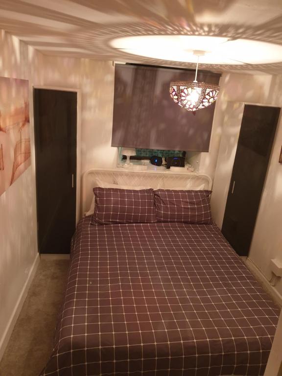 een bed in een kamer met een tv aan de muur bij Penbryn Holidays No 2 in Barmouth