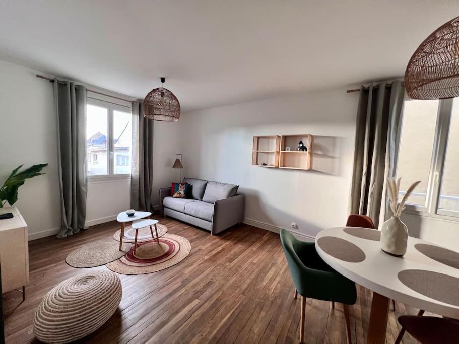 uma sala de estar com uma mesa e um sofá em Casa Paris - Paisible & Central T2 - Coeur de Brive - 4 Personnes em Brive-la-Gaillarde