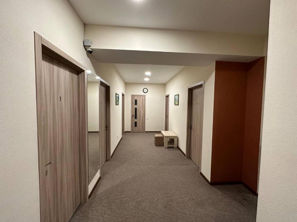 Un pasillo vacío con una fila de puertas y un pasillo cerrado en 5 Rooms near 300 Aragveli metro station, en Tiflis