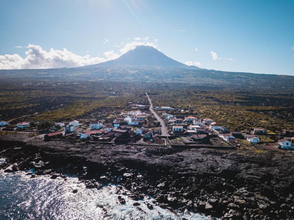 una vista aerea di una città con una montagna sullo sfondo di Casa das Ondas a São Roque do Pico