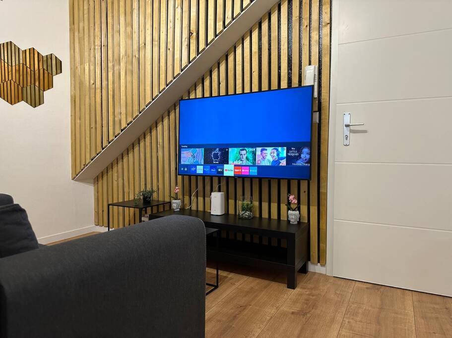 ein Wohnzimmer mit einem TV und einer Treppe in der Unterkunft Amazing Hyper Central Flat- Esch in Esch-sur-Alzette