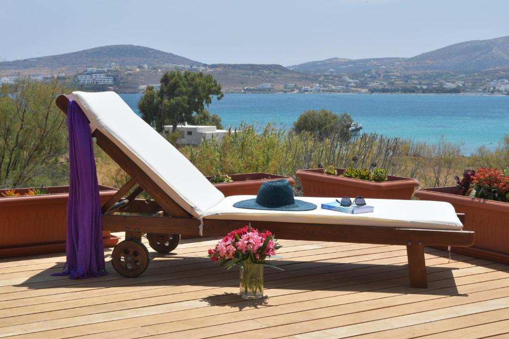 a white chair on a deck with a view of the water at Kolymbithres Seaside Villa in Kolympithres