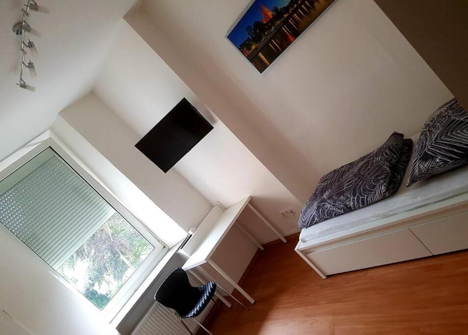 an attic room with a window and a couch at Helles Apartment in Neutraubling