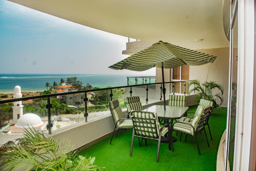ein Balkon mit Tisch und Stühlen und dem Meer in der Unterkunft The Zanakri homes Oceanfront in Mombasa