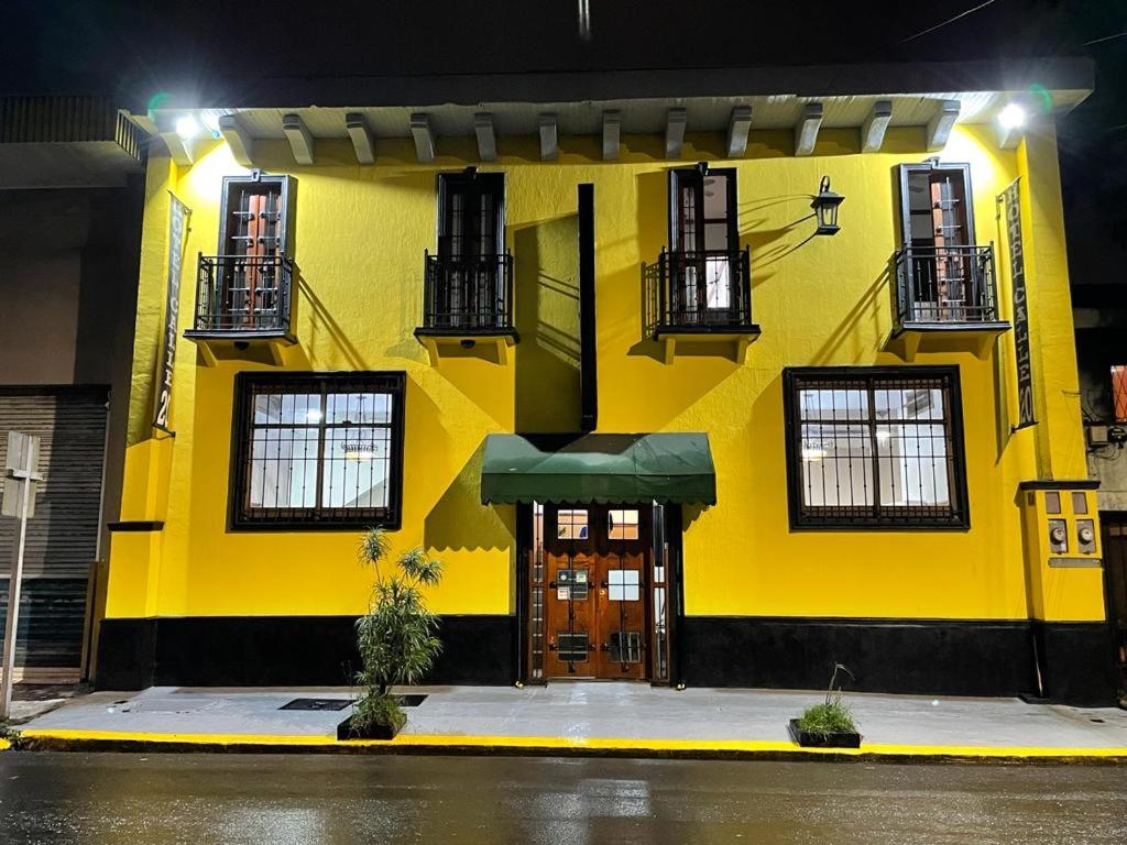 un edificio amarillo con puerta y ventanas en Boutique Hotel Calle 20, en San José