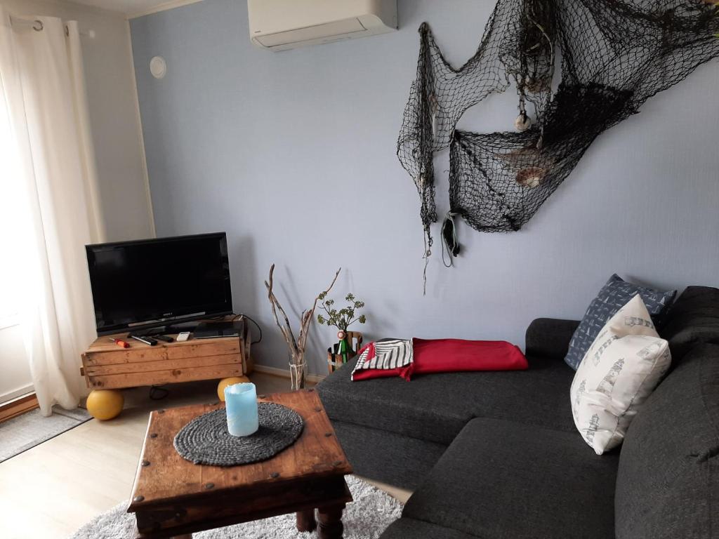 ein Wohnzimmer mit einem Sofa und einem Tisch in der Unterkunft Holiday Apartment in Flatanger in Vik