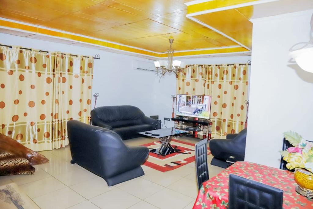 a living room with leather chairs and a television at Ocean Breeze in Limbe