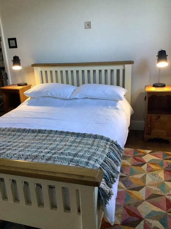 1 dormitorio con 1 cama blanca grande y 2 lámparas en The Views Bed and Breakfast, en Llangollen
