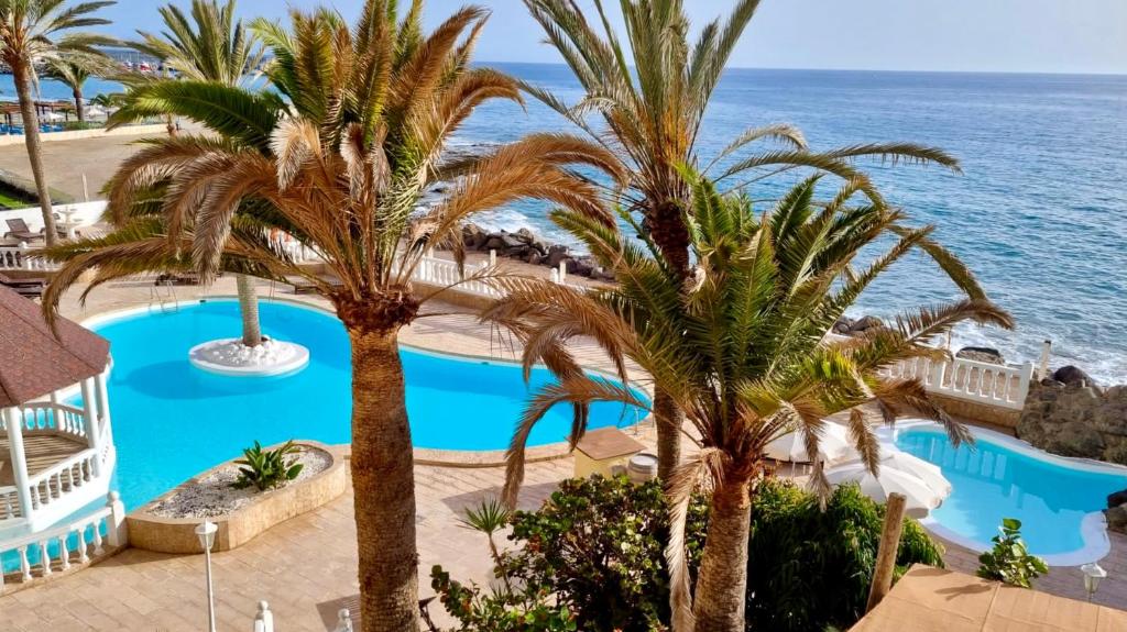 einen Luftblick auf ein Resort mit Palmen und dem Meer in der Unterkunft Beach Point Ocean View Suite in Arguineguín