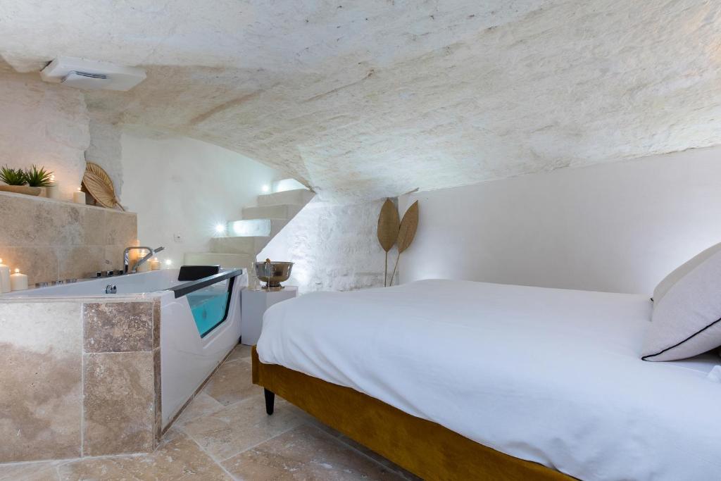 a bedroom with a bed and a tub in a room at La loge de Sarah in Montpellier