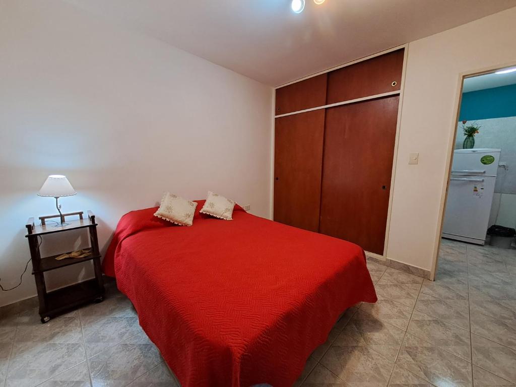 1 dormitorio con 1 cama con manta roja en Vientos Del Sur en Río Gallegos