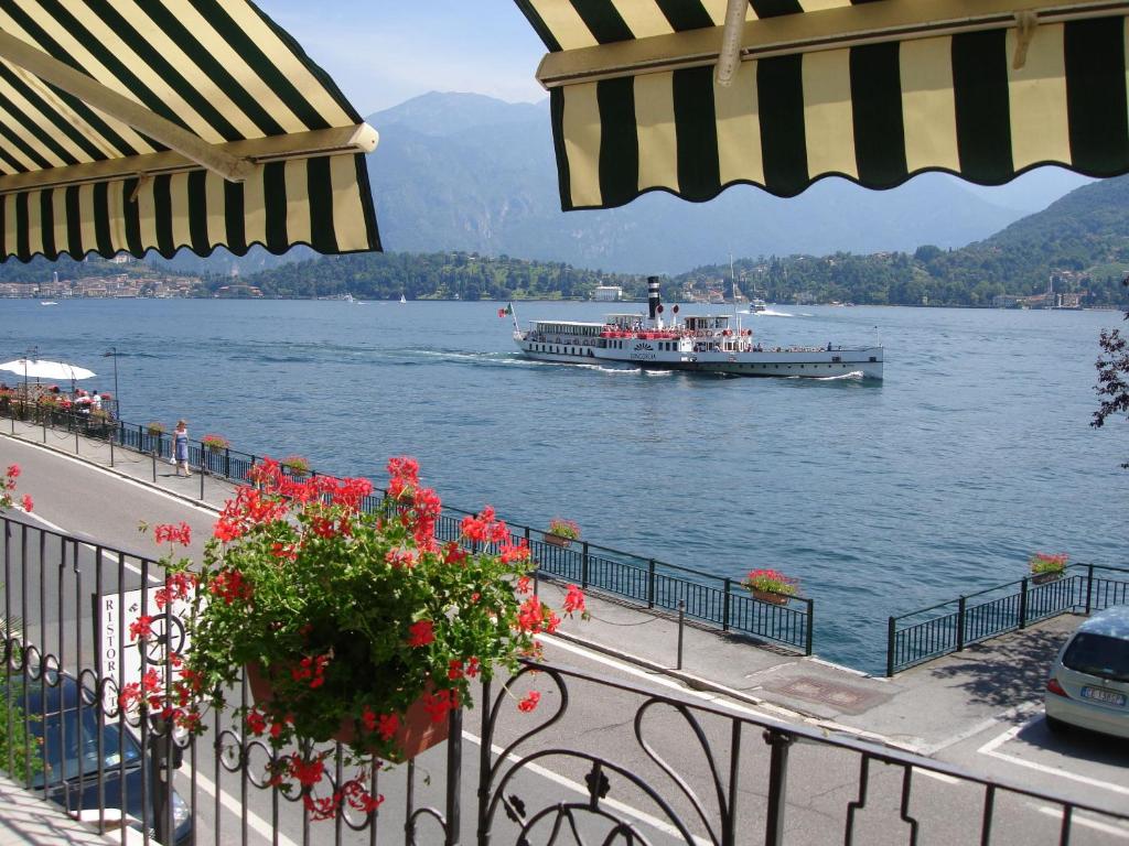 a large boat on the water with people on it at Tremezzo Bella Vista - lake front - lake view in Tremezzo