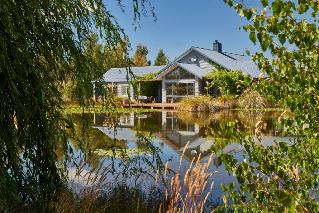 a house with a pond in front of it at Matuka Lodge in Twizel