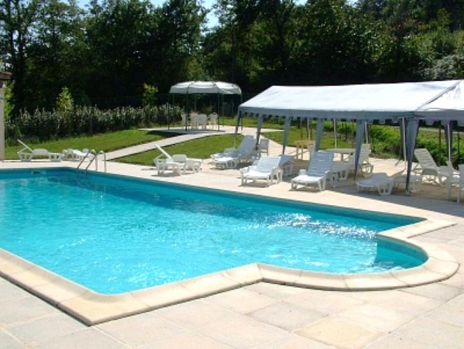 a swimming pool with chairs and a gazebo at Les Albizias 5 in Eugénie-les-Bains