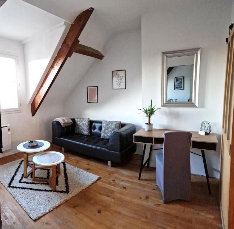 ein Wohnzimmer mit einem Sofa und einem Tisch in der Unterkunft Appart plein centre, vue cathédrale, fibre in Lisieux