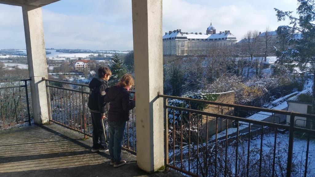 two people standing on a balcony looking at the city at gite du chateau de champlitte in Champlitte-et-le-Prélot