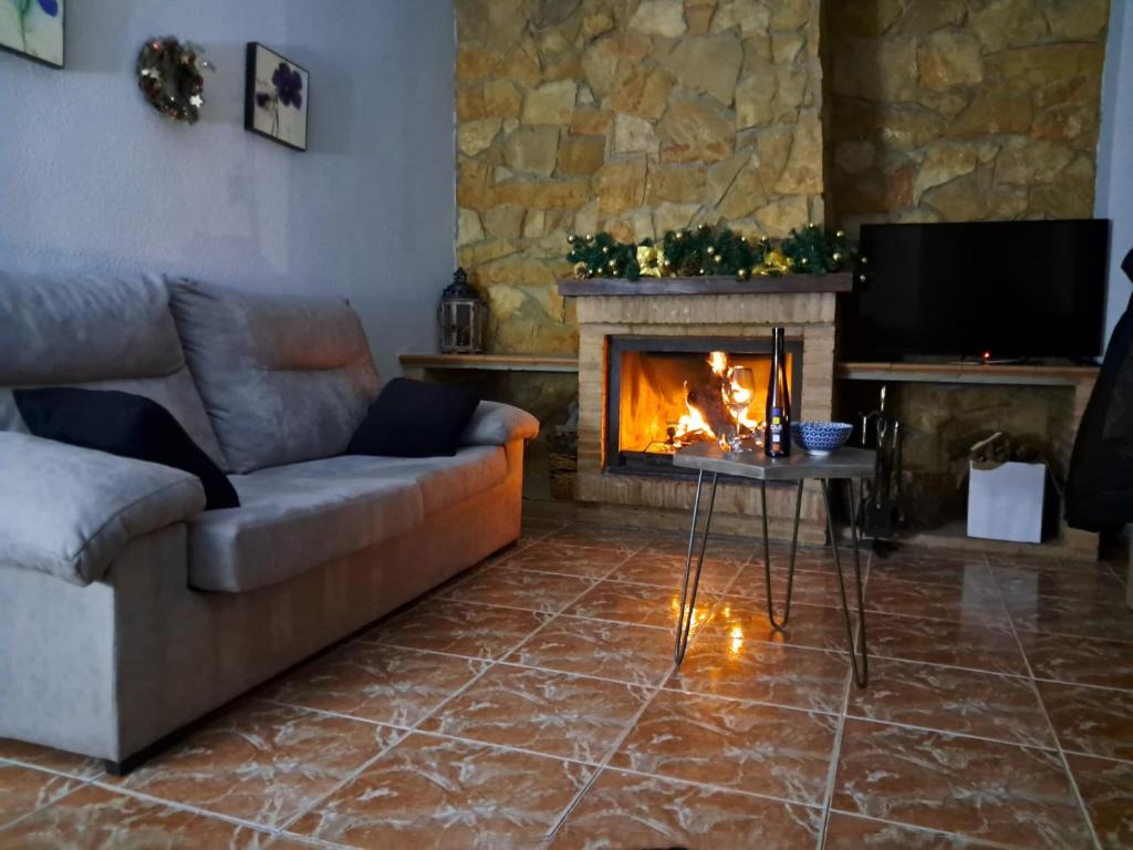 - un salon avec un canapé et une cheminée dans l'établissement LA CAÑADA, à Alcalá del Júcar