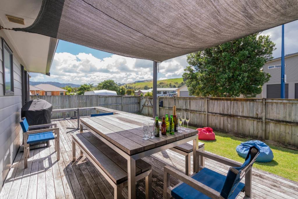 een terras met een tafel en stoelen bij Hosts on the Coast Peaceful Dotterel in Whitianga