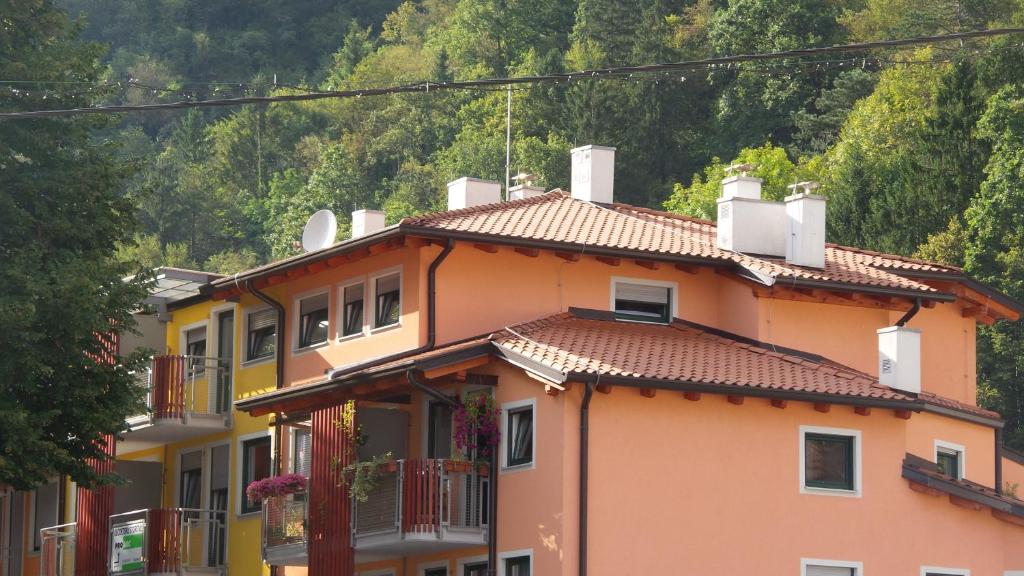 een oranje huis met een berg op de achtergrond bij Apartment Alvarium in Kobarid