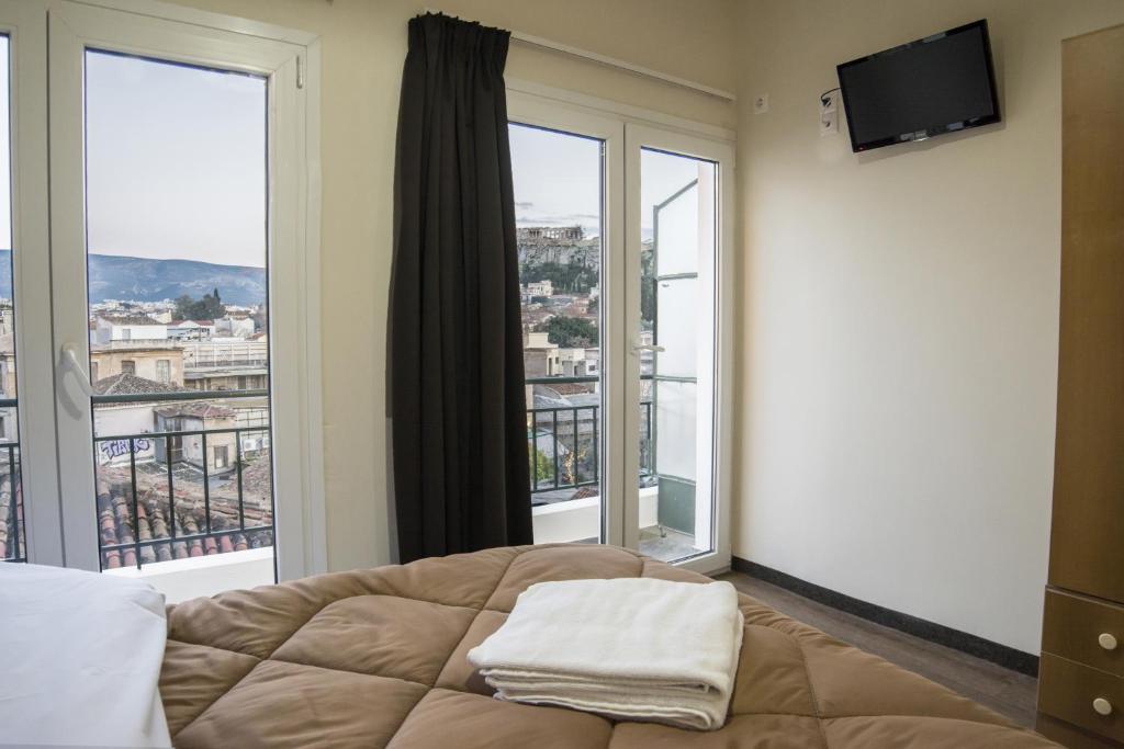 a bedroom with a bed and a large window at Pella Inn Hostel in Athens