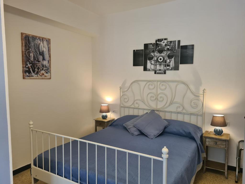 a bedroom with a bed with blue sheets and two lamps at Pippo a Vernazza Rooms in Vernazza