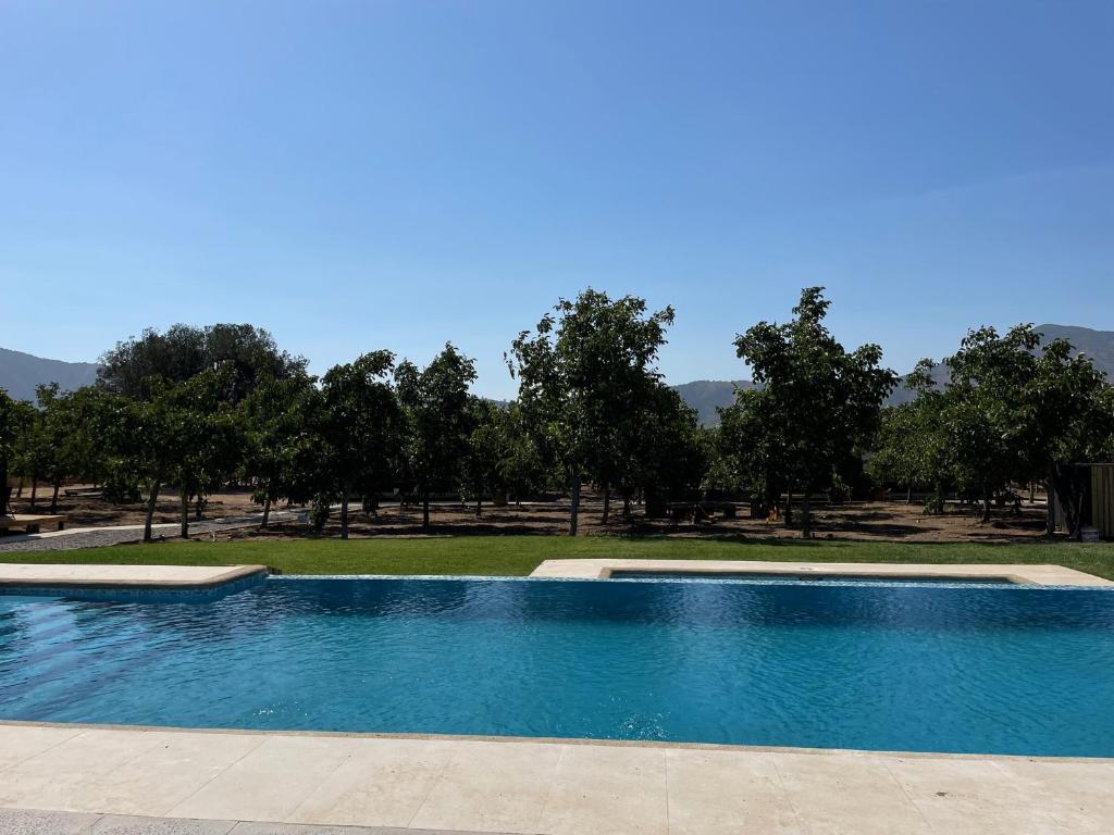 una piscina blu con alberi sullo sfondo di Cabañas Pachamama Casablanca a Casablanca